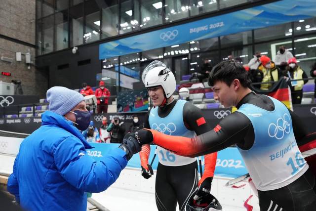 广东雪橇运动员彭俊越（右）与国际奥委会主席巴赫碰拳致意（图：李木子）
