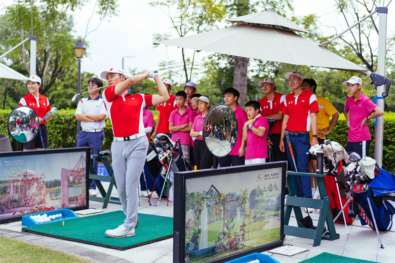 省高尔夫球队队员们为当地青少年展示挥杆击球动作.jpg